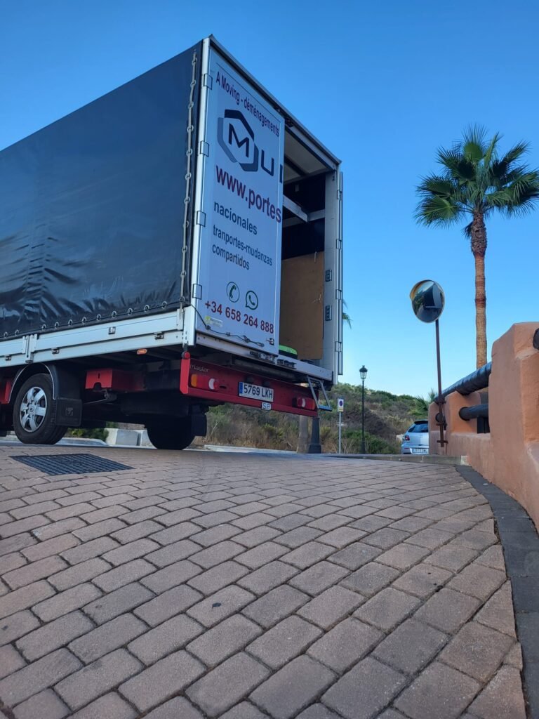 Camión de Mudanzas Mudena con trampilla elevadora cargando material de oficina y equipos inform